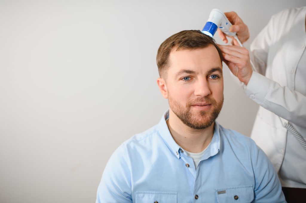 a trichologist examines the hair of a man who begi 2026 03 24 01 27 50 utc