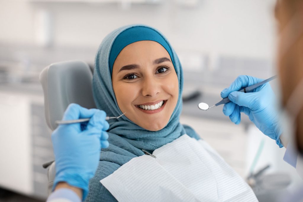 happy muslim woman sitting at dentist chair and sm 2026 03 24 01 28 56 utc