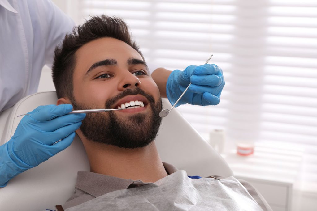 dentist examining young man s teeth in modern clin 2026 03 09 02 54 01 utc