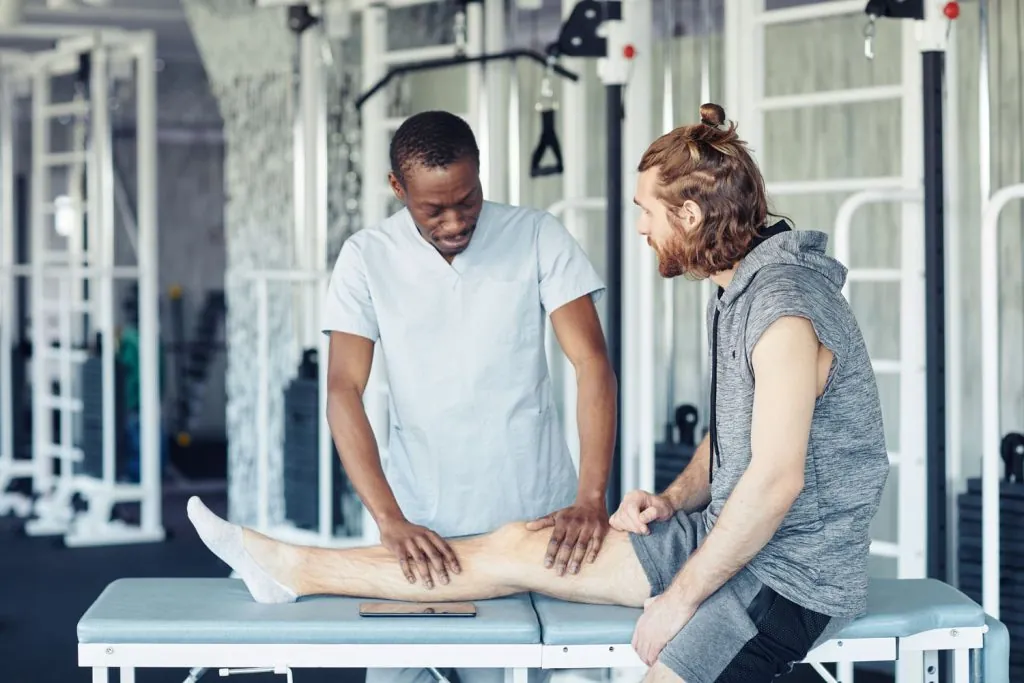 doctor making massage on leg to patient 2026 03 19 22 09 11 utc